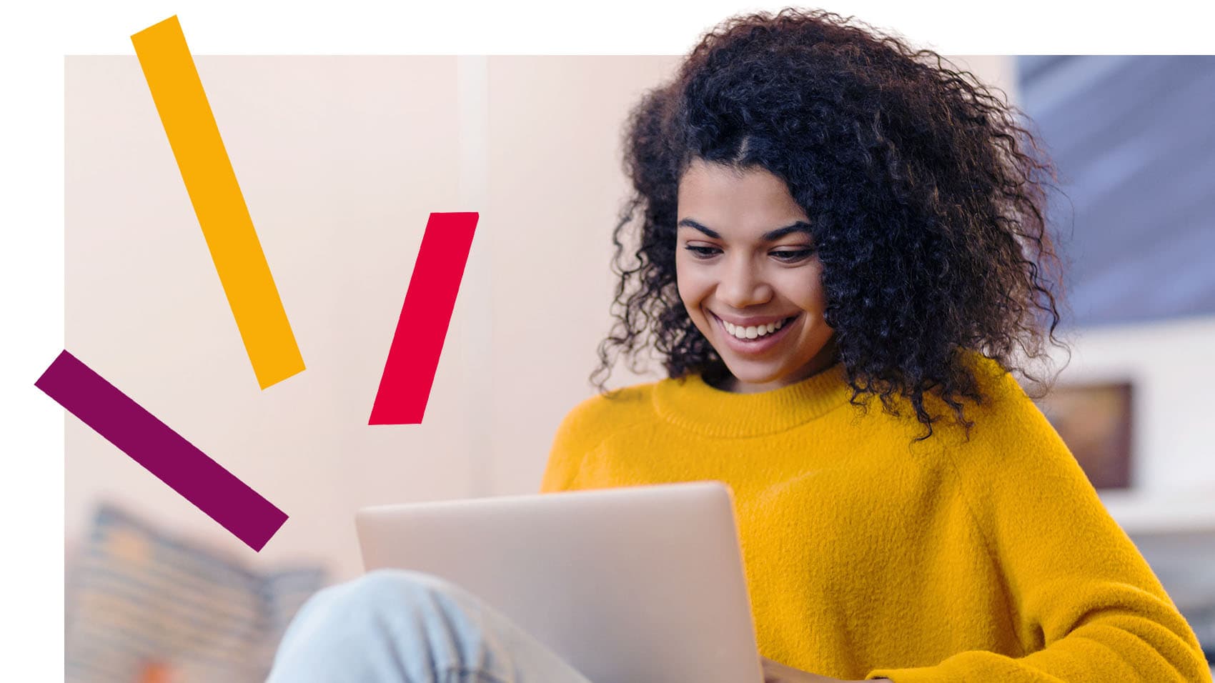 Smiling female in yellow jumper smiling at laptop