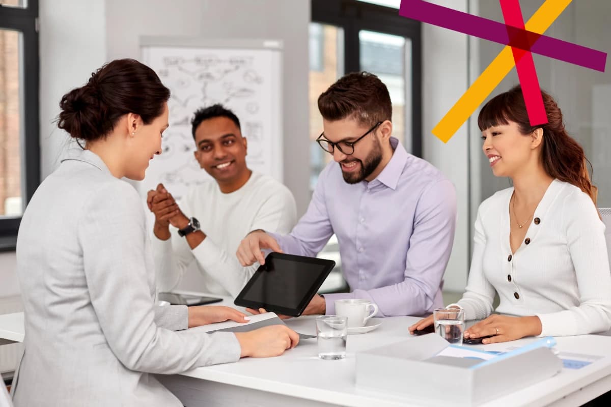 People at desk looking at tablet