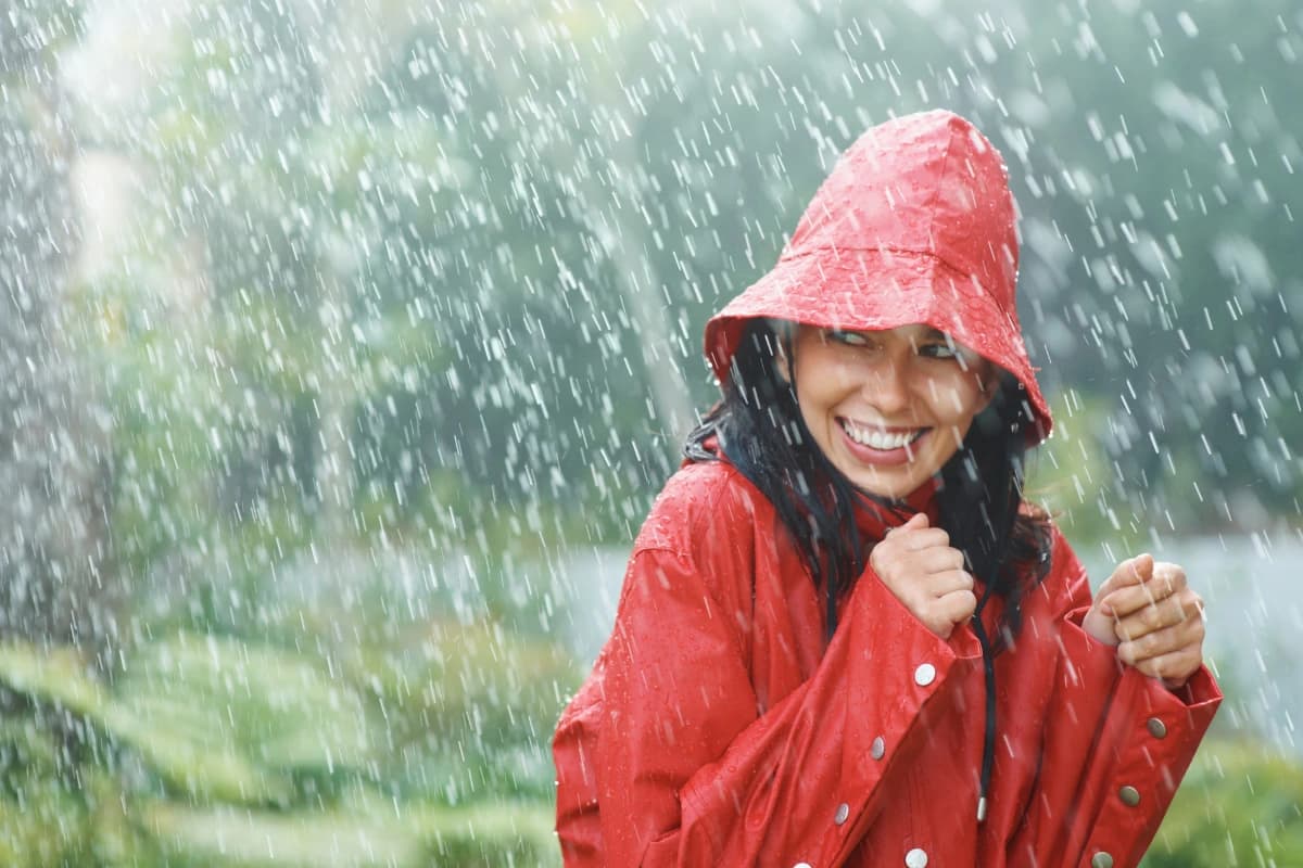 Woman in red coat while its raining 