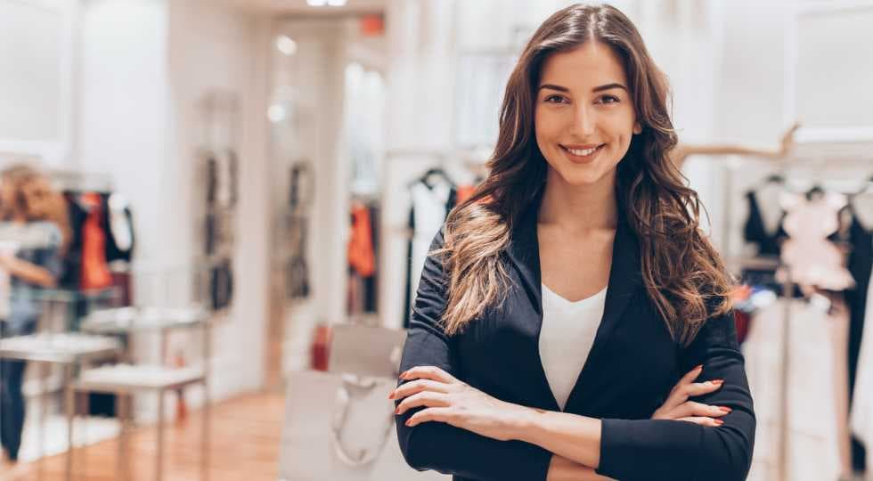 Female shop assistant smiling with crossed arms 