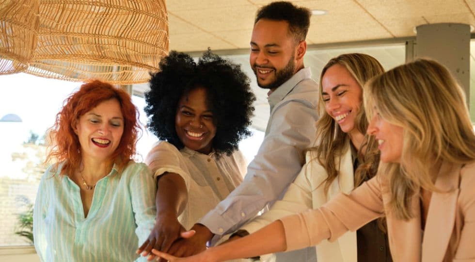 Group of people smiling with hands together