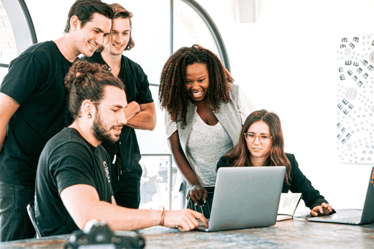 Group pf people at a desk looking at laptop