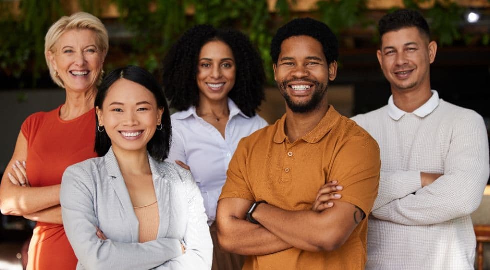 Group of people smiling with arms crossed