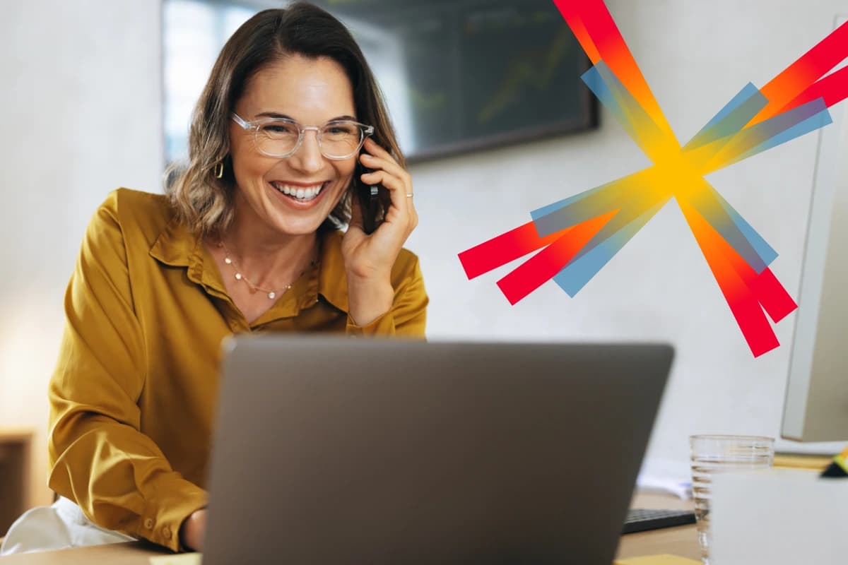 Woman at desk on phone and laptop