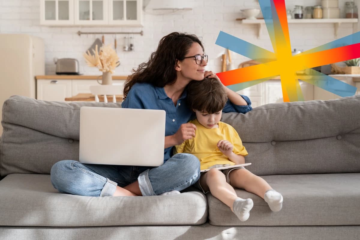 Woman on sofa with child and laptop